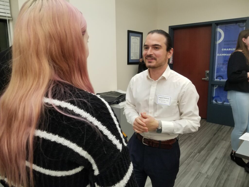 A man talks with a woman during a networking event.